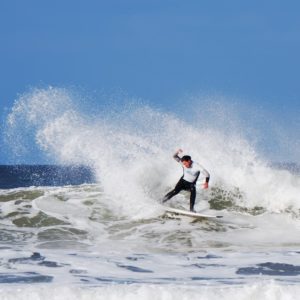 Surfer performing a slash at Putsborough Beach