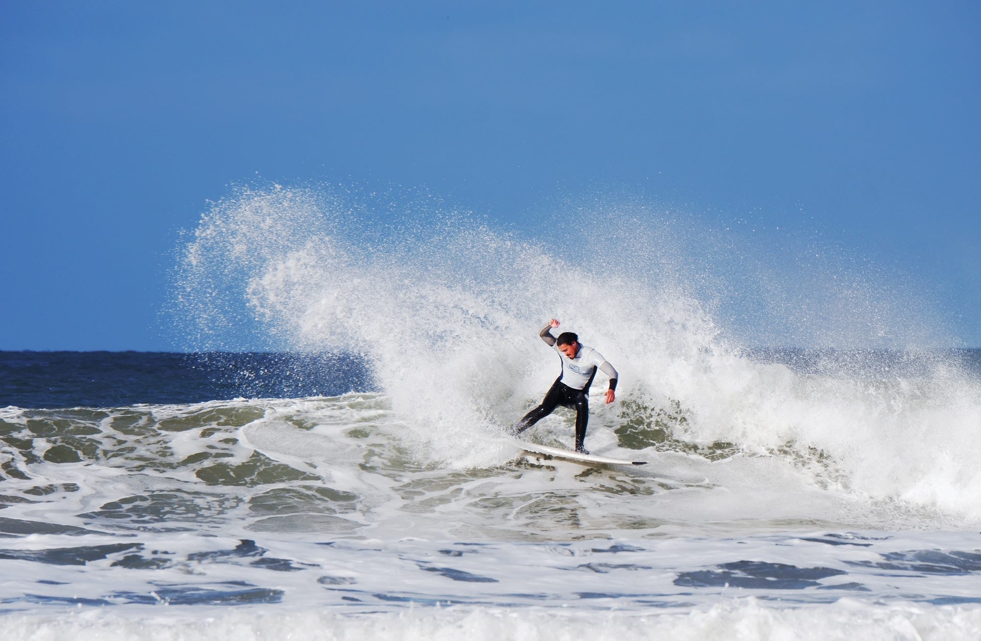 Surfer performing a slash at Putsborough Beach