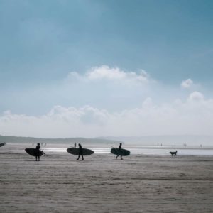 Surfers Walking On Saunton Sands