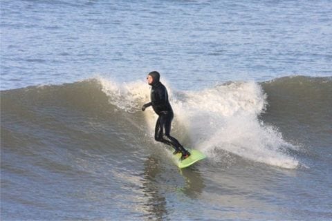 Surfing in a full wetsuit at Westward Ho!