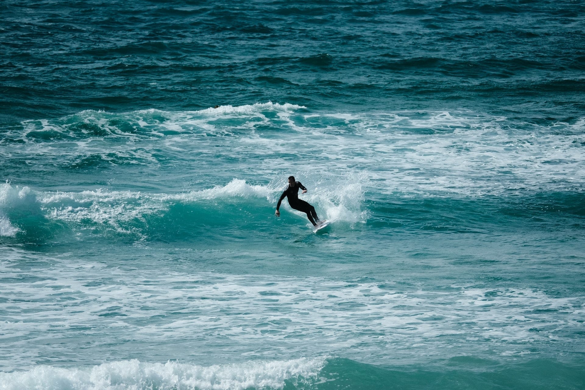 Surfer cutting back on waves at Fistral beach, newquay, cornwall