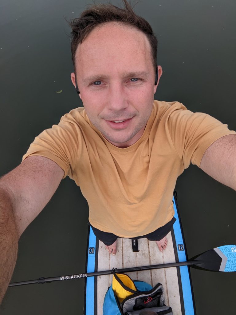 Tom standing on the paddle board on the thames