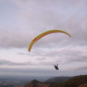 Paraglider flying over hills