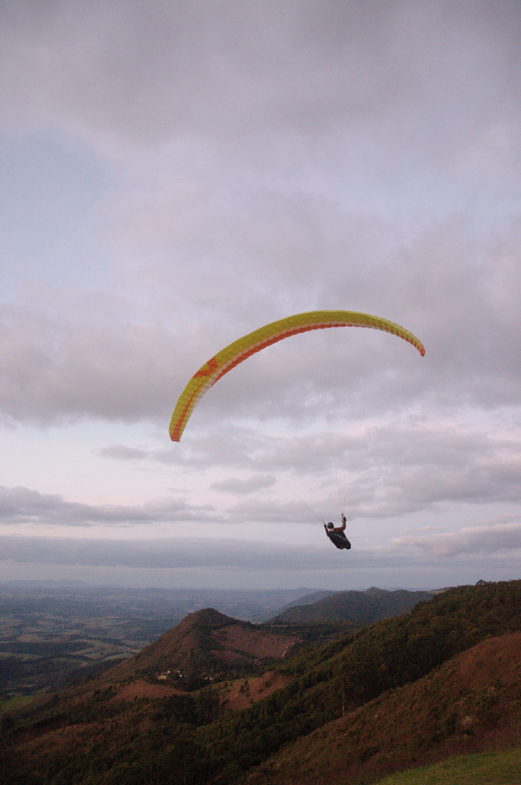 Paraglider flying over hills