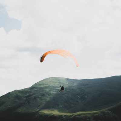 Paraglider flying over mountains