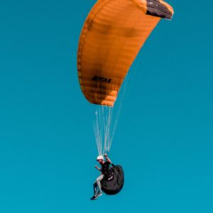 Paraglider in pembrokeshire wales in the sky with blue background