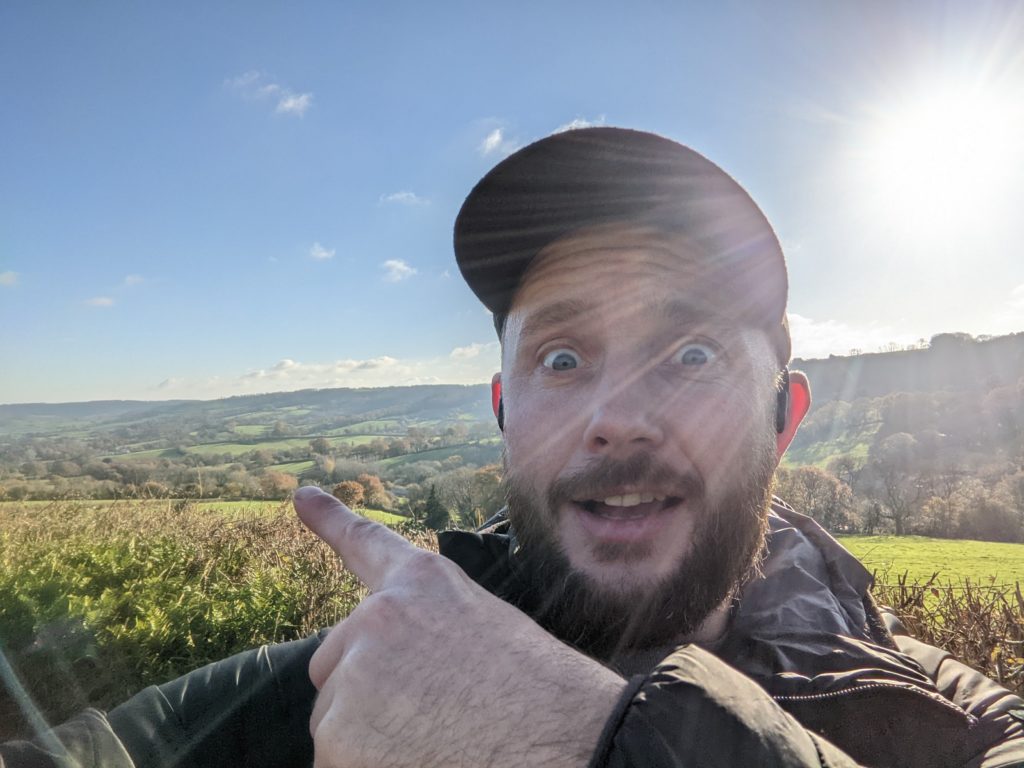 Tom pointing to the countryside on the east devon way